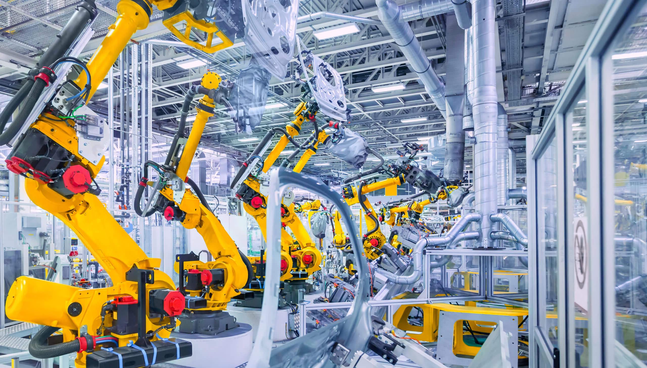 Yellow robotic arms in a manufacturing plant