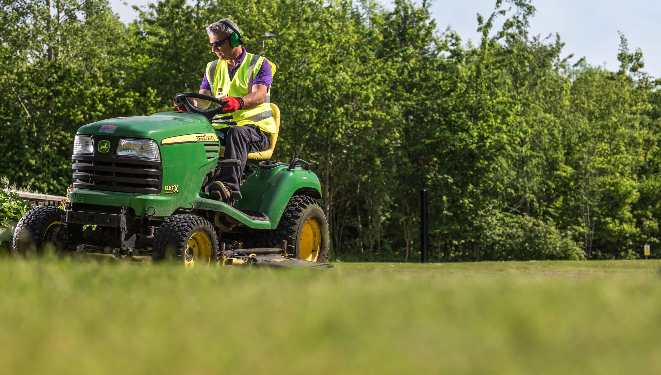 Mitie Landscaping employee on a ride-on mower