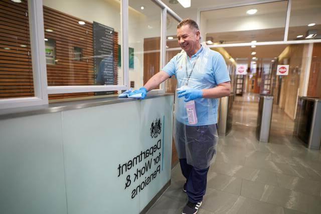 Mitie cleaner wiping a counter at the Department for Work & Pensions